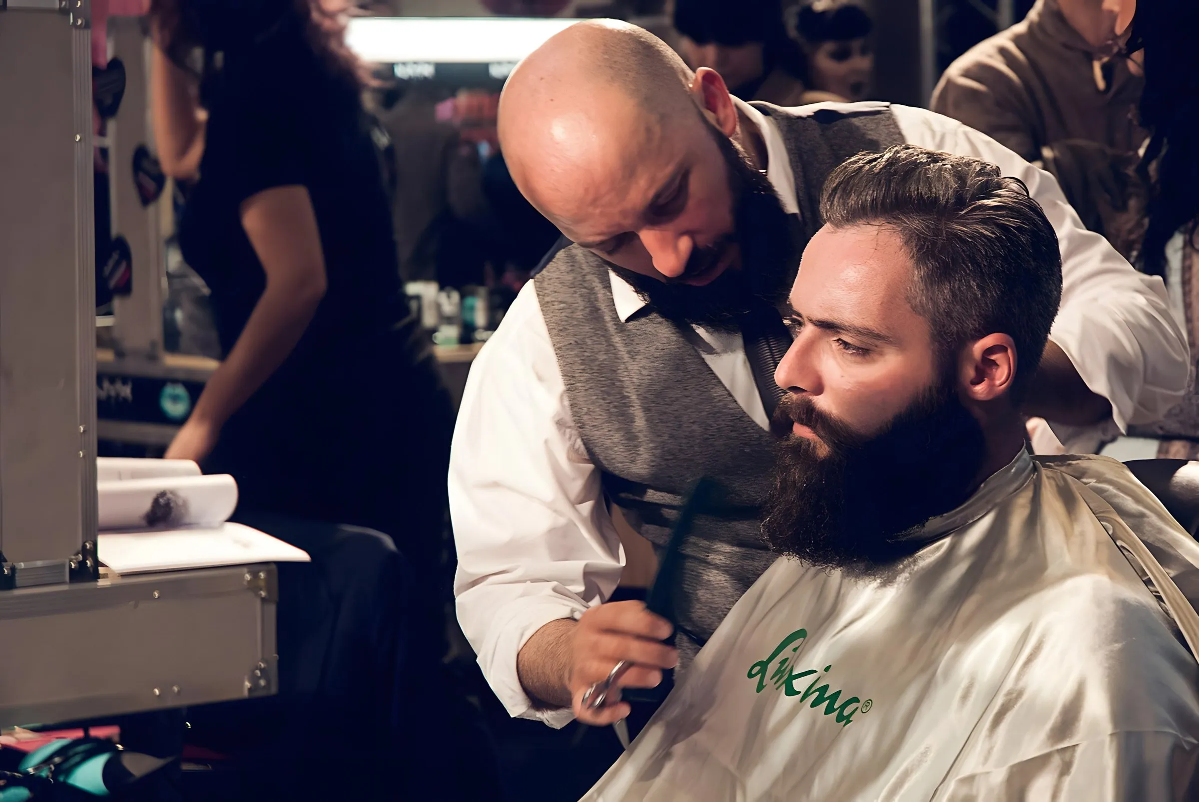 A barber trimming a customer’s beard
