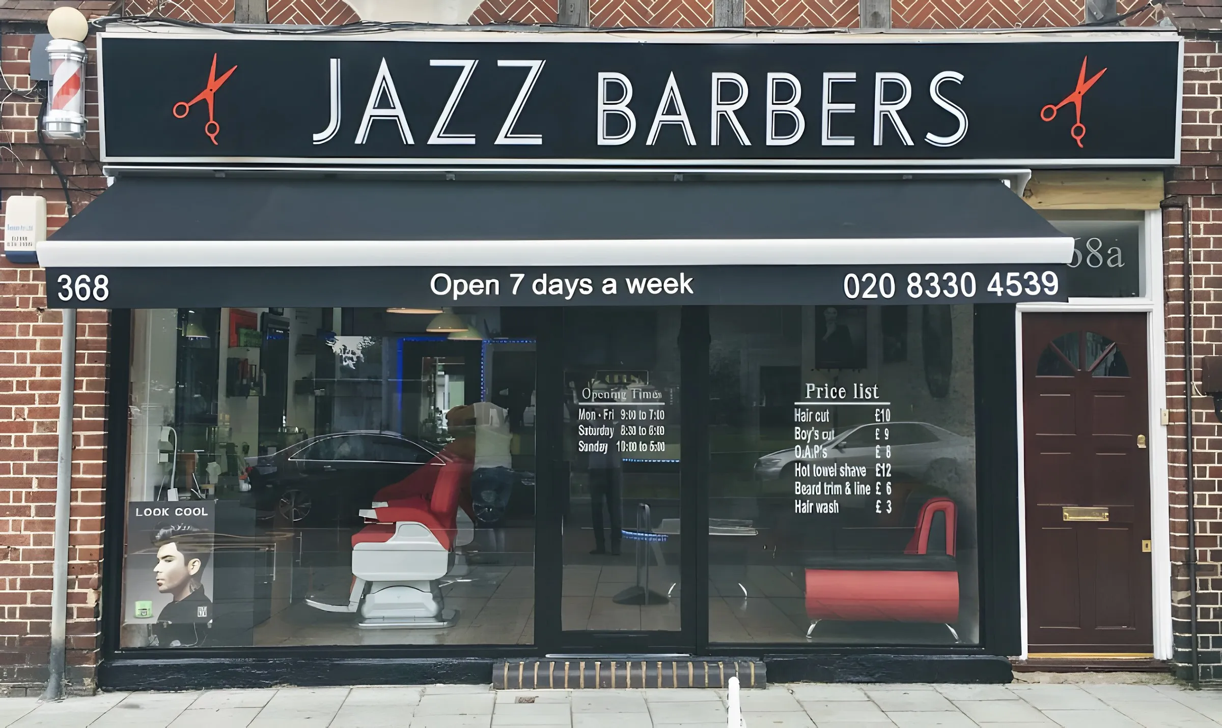 The Jazz Barbers shopfront on Malden Road, with its black sign and red barber chairs